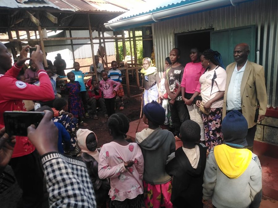 Joram's new home, dedicated with his community gathered around
